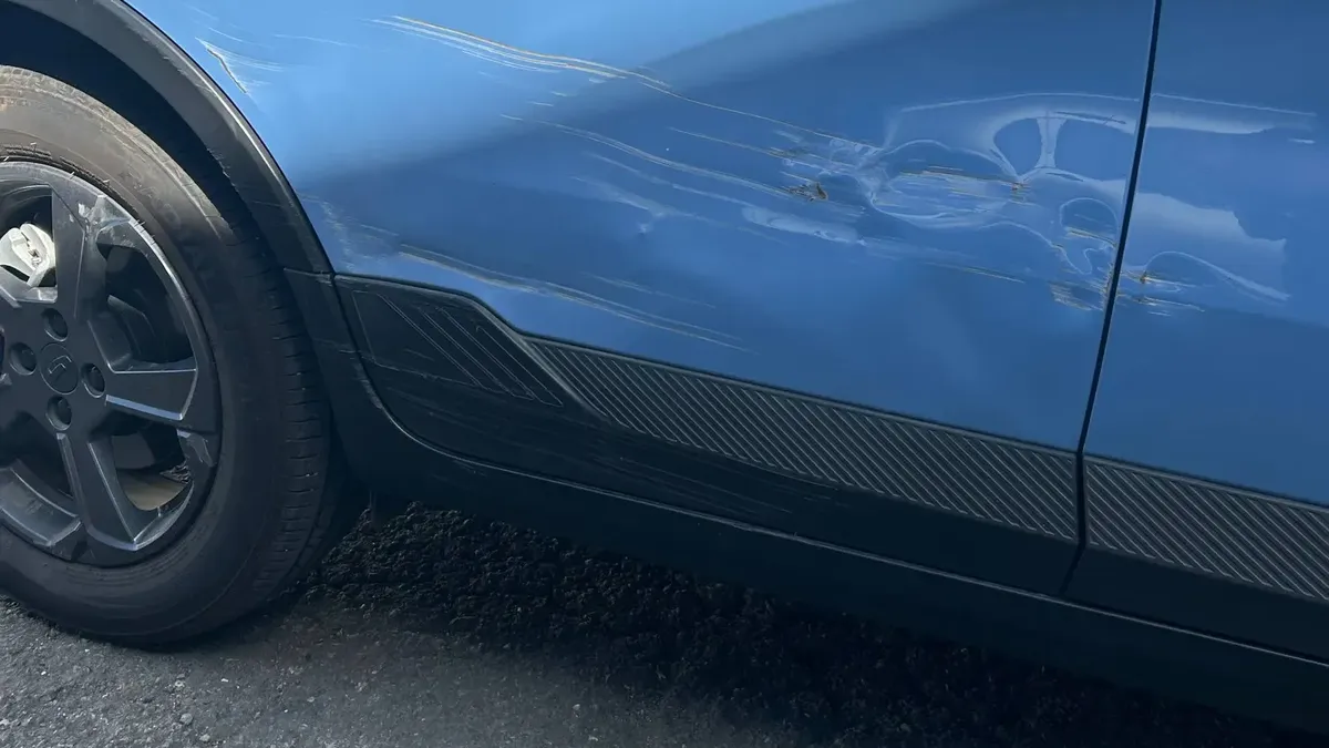 Rayones y golpe en el costado de un Geely Geometry E antes de repararlo