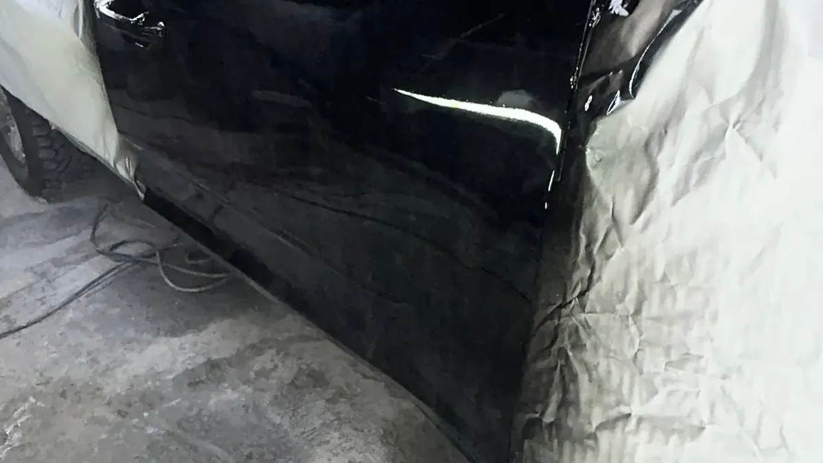 Puerta de una Maxus T60 negra recién pintada en la cabina de Latin Garage